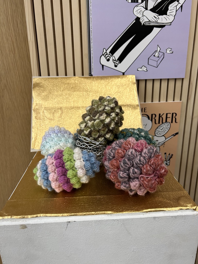 Three crochet grenades on a dislay stand.